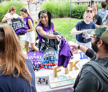 student passing out tshirts